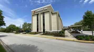 A Comfort Inn hotel with a modern design, featuring a prominent entrance and a parking lot.