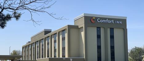 A Comfort Inn hotel with a modern architectural design, featuring a prominent logo on the facade.
