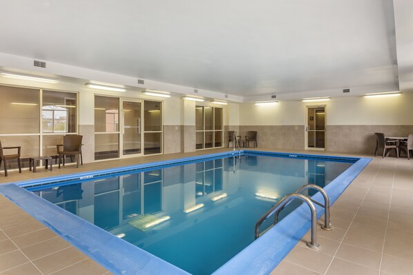 Relax by the pool surrounded by comfortable seating and large windows.