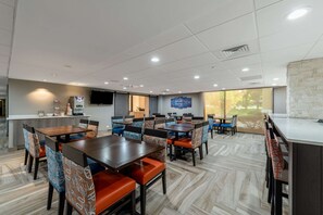 Enjoy meals in this stylish dining area with multiple seating options and a large window offering a view of the outdoors.