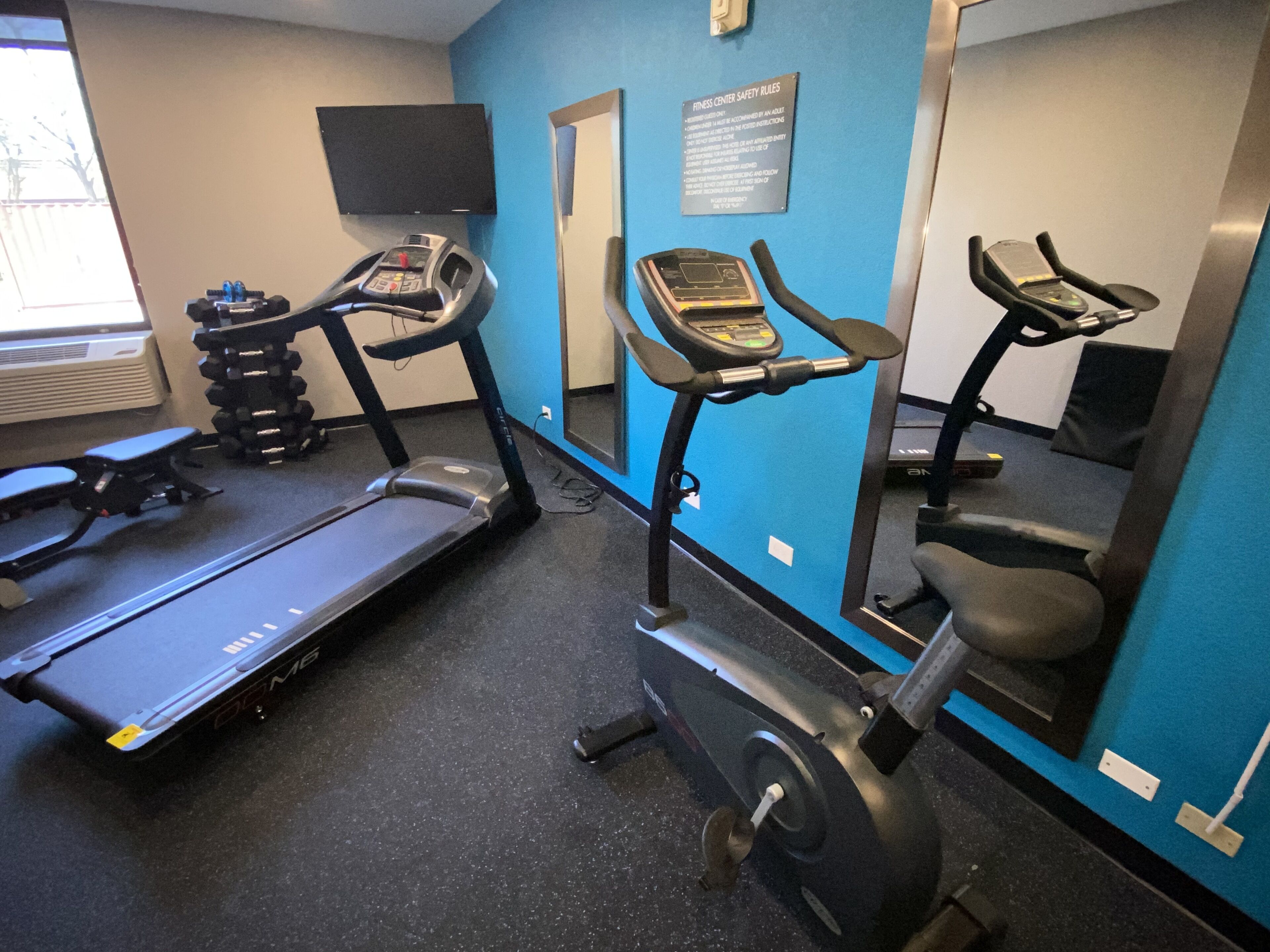A gym with treadmills, a stationary bike, and a mirror.