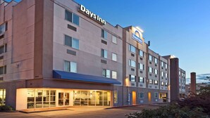A Days Inn hotel with a modern design, featuring a prominent sign and a well-lit entrance. - Days Inn by Wyndham Seatac Airport (SeaTac)
