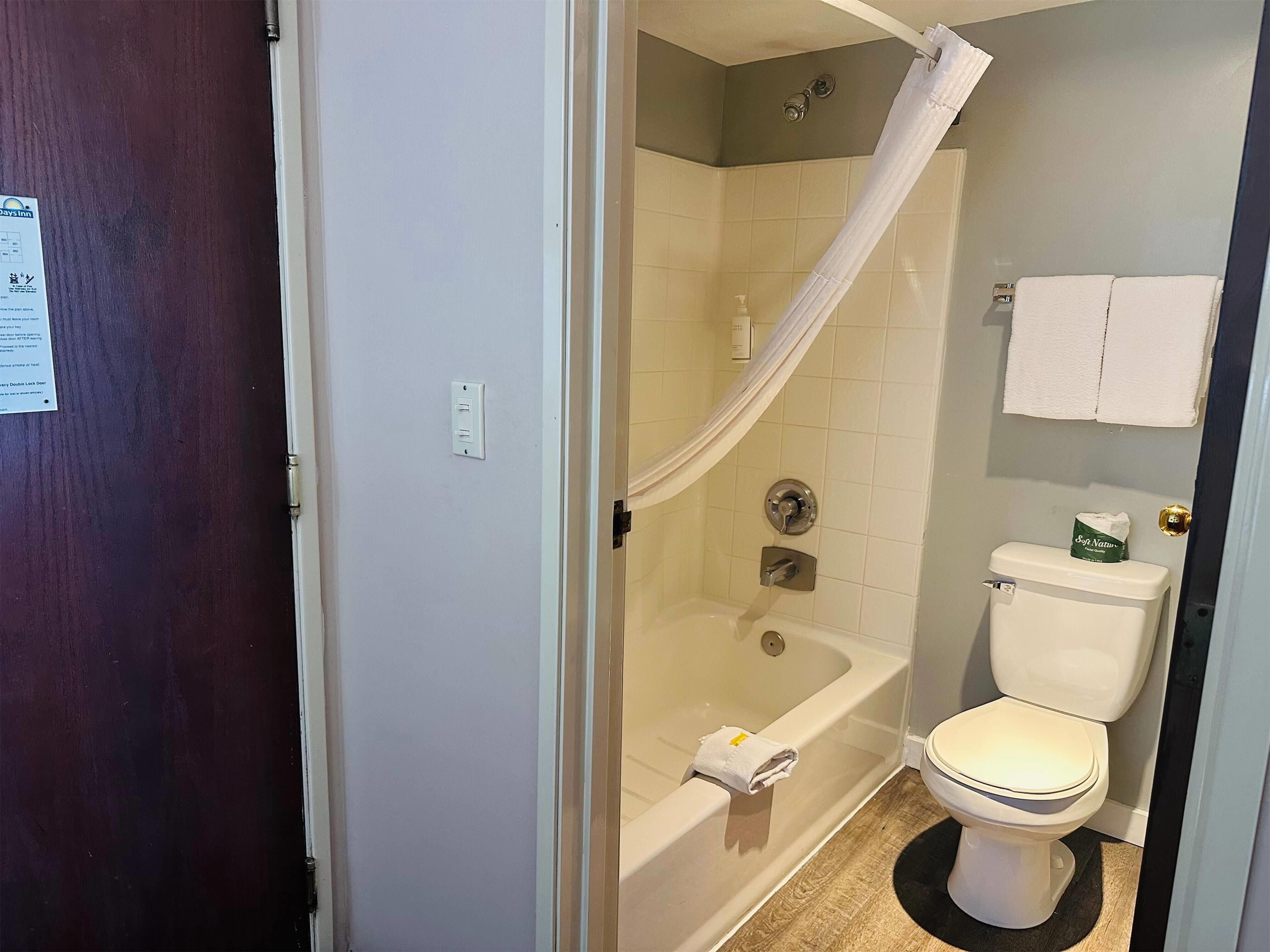 Ein Badezimmer mit Badewanne, Toilette und Duschvorhang.