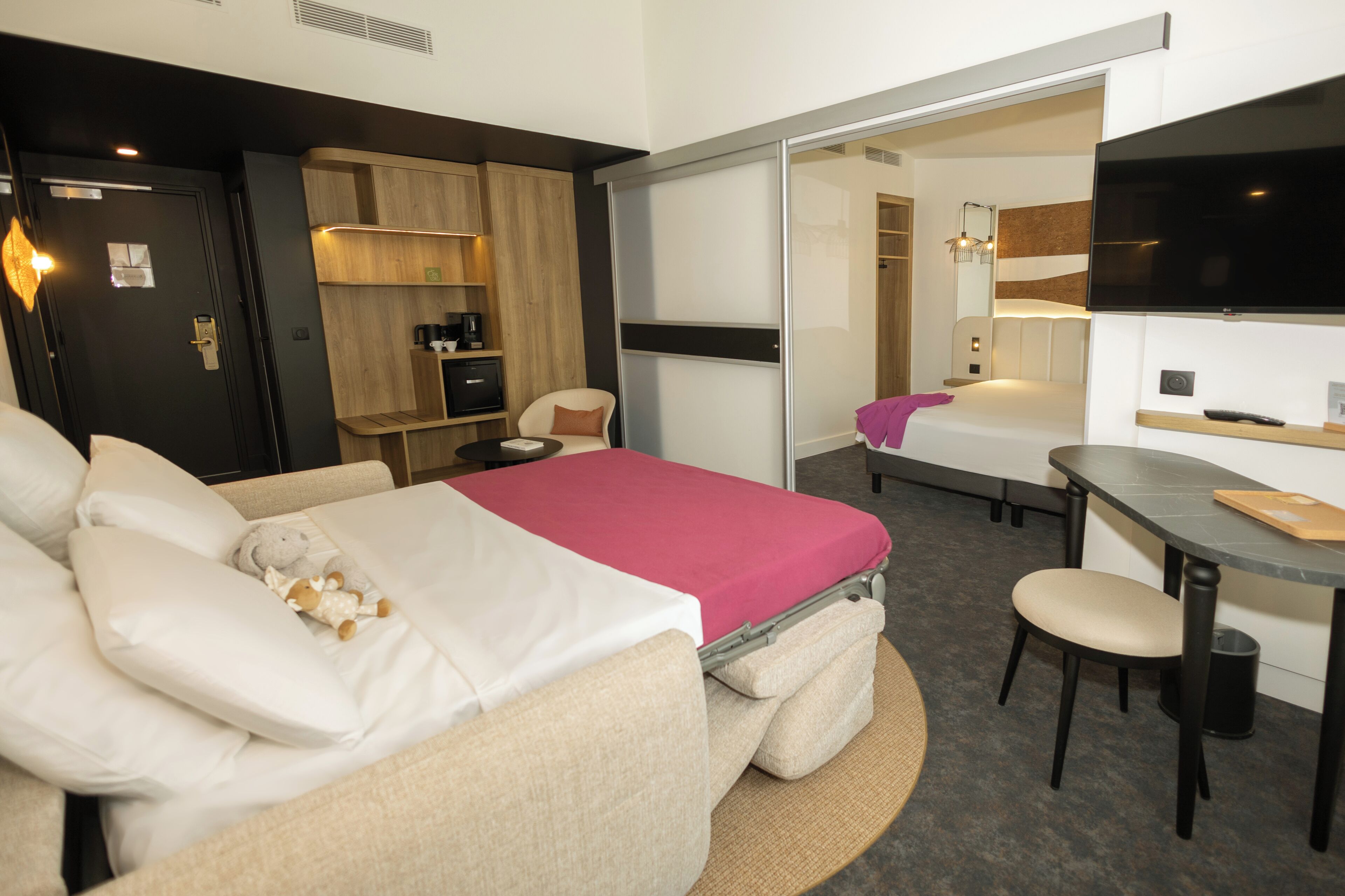 Une chambre d’hôtel moderne équipée d’un lit, d’un bureau et d’un coin salon.