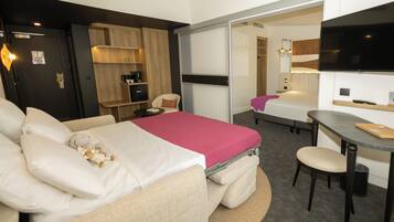 Une chambre d’hôtel moderne équipée d’un lit, d’un bureau et d’un coin salon.
