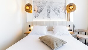 A modern bedroom with a large bed, two bedside tables, a chair, and a wall-mounted artwork. - Mercure Beaune Centre (Beaune)
