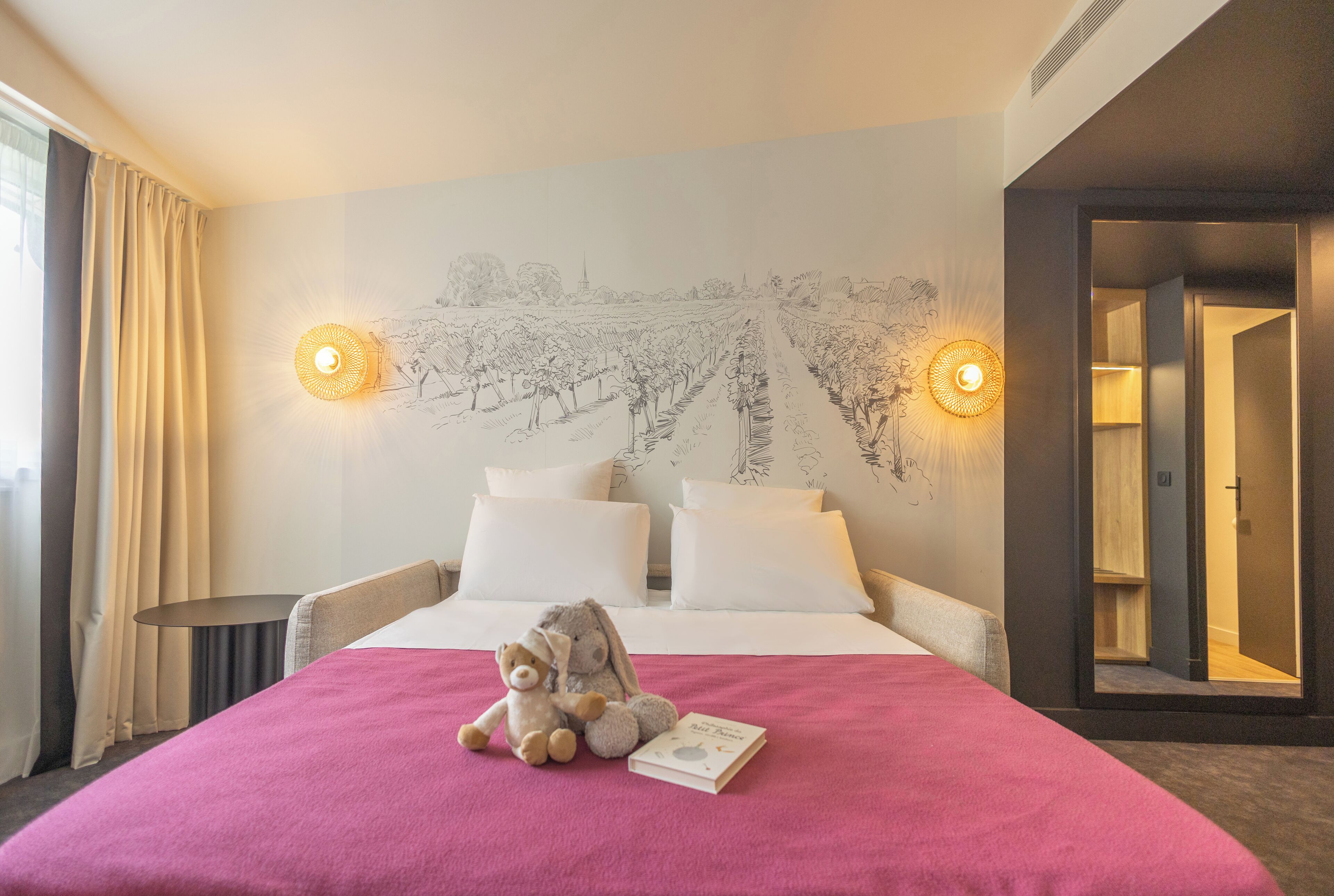 A hotel room with a bed, a plush toy, and a wall-mounted map.