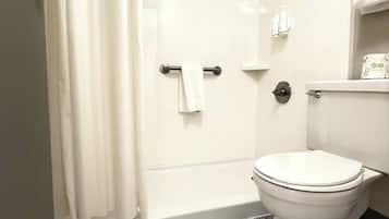 Une salle de bain avec des toilettes, une douche et un sol en marbre.