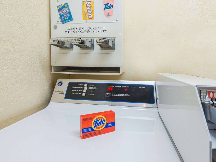 Une laverie automatique où l’on peut utiliser des pièces de monnaie et où sont disponibles le détergent Tide et les essuie-tout Bounce.