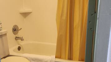 Ein Badezimmer mit Toilette, Badewanne und Duschvorhang.