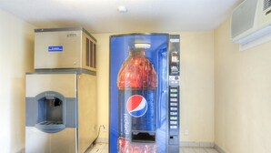 Una máquina expendedora con el logotipo de Pepsi, un dispensador de agua y una unidad de aire acondicionado.
