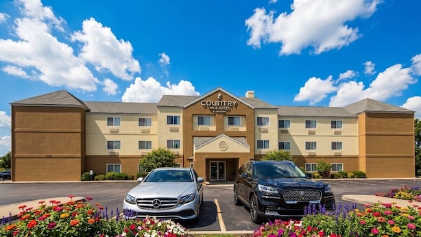 A Country Inn & Suites hotel with a two-story structure, a parking lot, and a landscaped front with flowers. - Country Inn & Suites by Radisson, Coeur d'Alene (Coeur d'Alene)