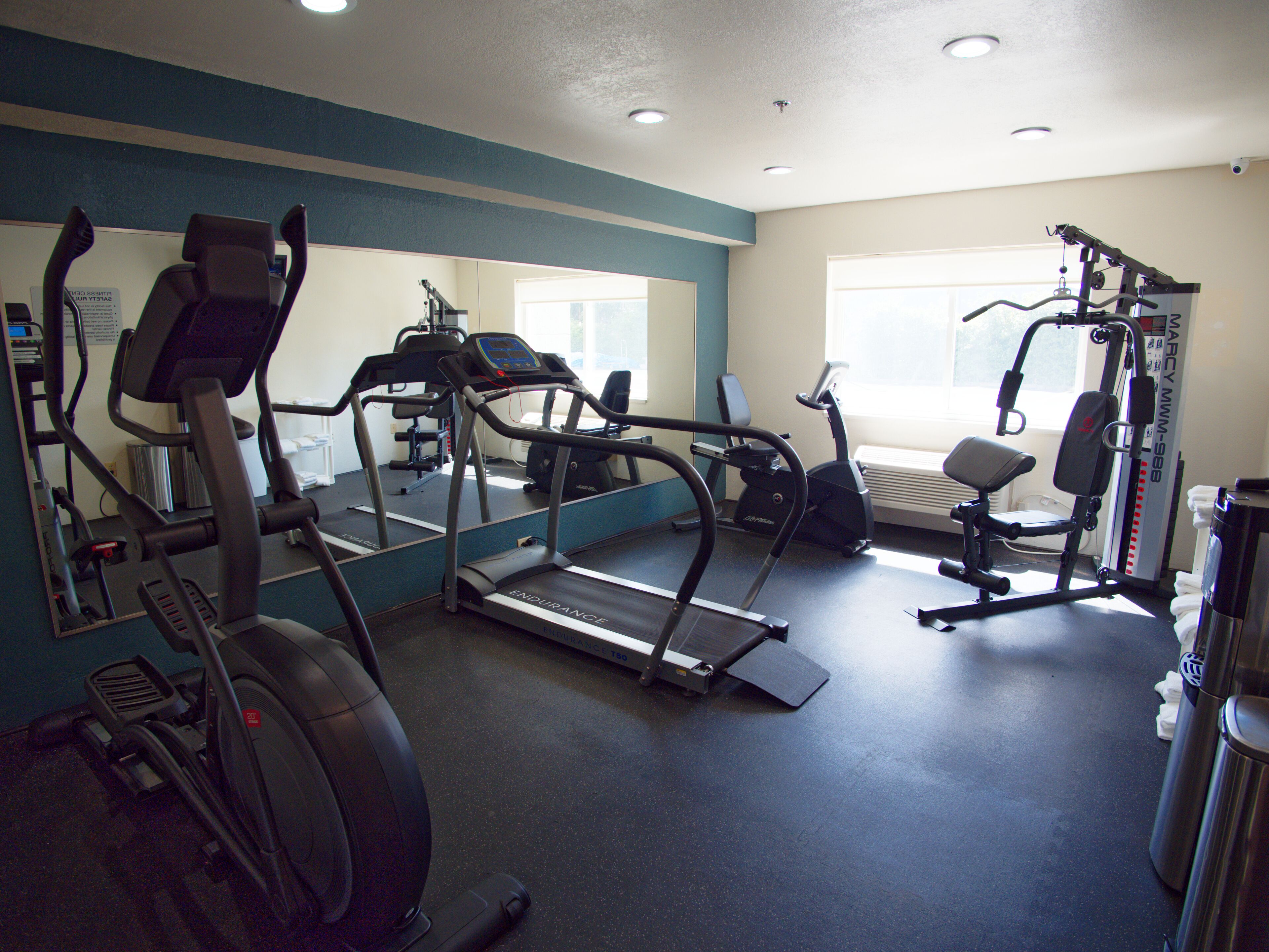 Ein Fitnessstudio mit Laufbändern, Crosstrainern und Gewichten.
