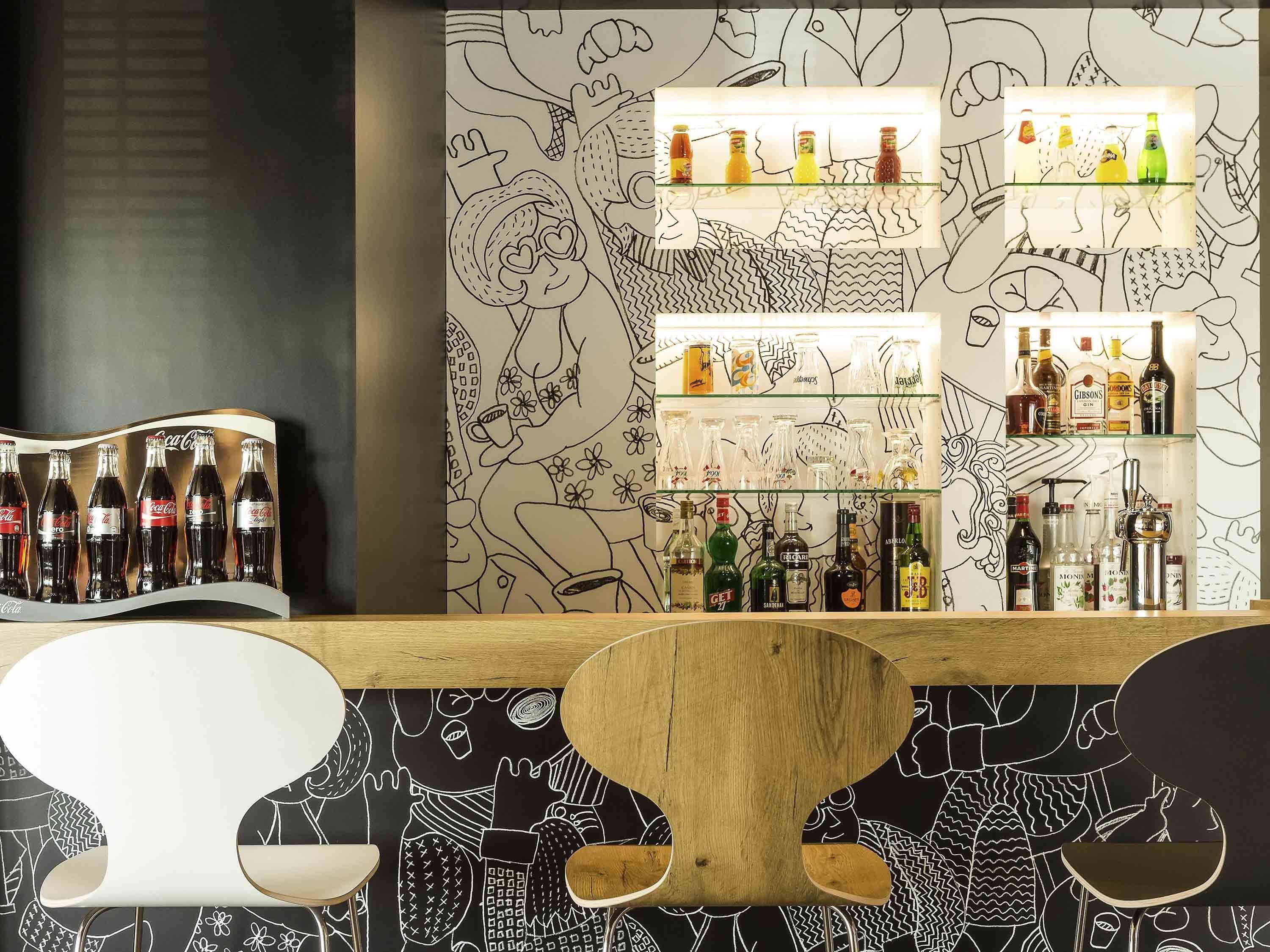 Zona de bar con estantes de bebidas y una barra de madera.