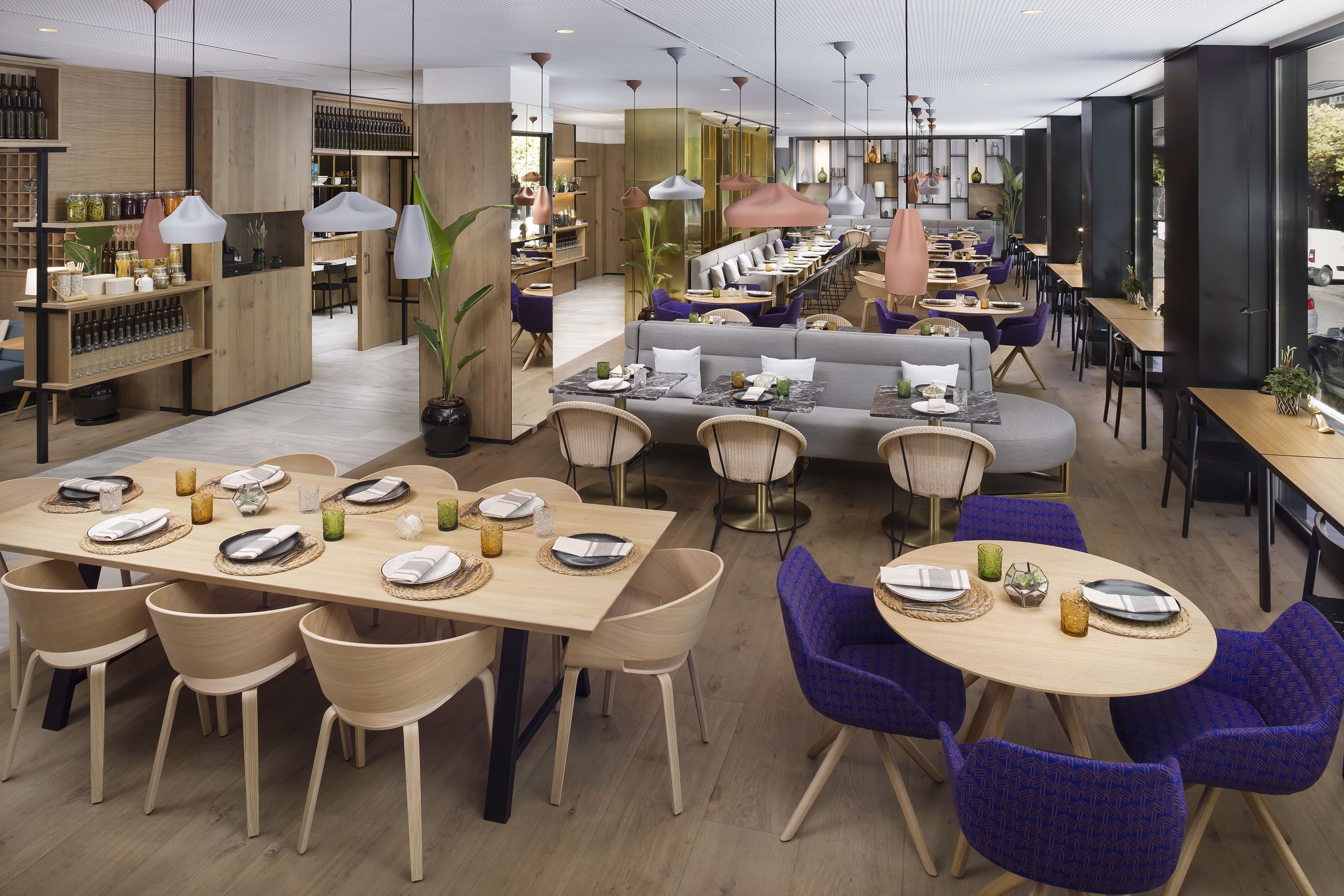 Moderni ravintola, jossa on puuhuonekalut, pyöreät pöydät ja violetit tuolit.