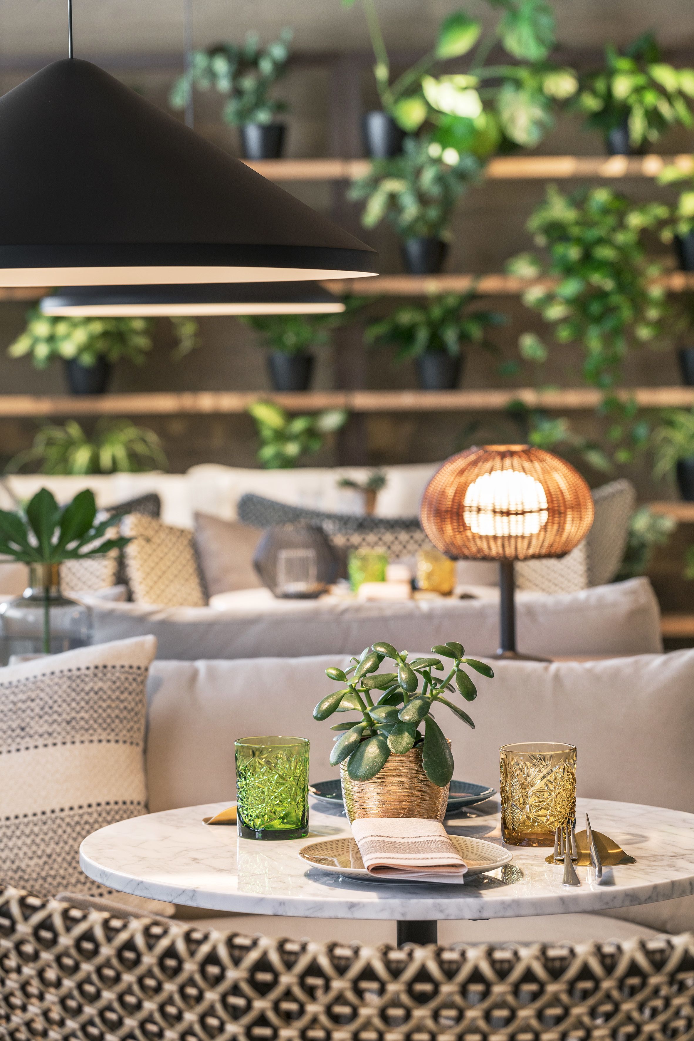 Ein gemütlicher Sitzbereich mit rundem Tisch, einer Hängelampe und einer Stehlampe.