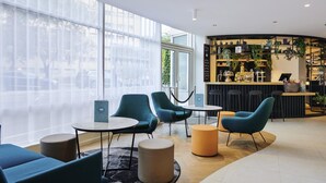Una moderna area lounge con posti a sedere, un bar e ampie finestre.