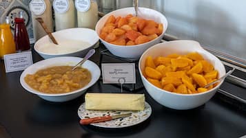 A buffet with various food items including yogurt, soup, cheese, and fruit.