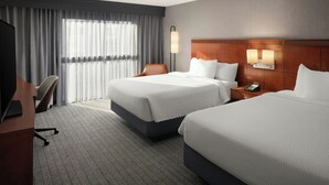 A hotel room with two beds, a desk, a chair, a lamp, and a phone on the nightstand. - Courtyard by Marriott Portland Beaverton (Beaverton)
