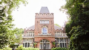 A large brick building with a central tower, multiple windows, and a symmetrical facade. - Kasteel Kerckebosch (Zeist)