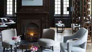 A spacious lobby with a large bull head sculpture, a fireplace, and comfortable seating areas. - Kasteel Kerckebosch (Zeist)