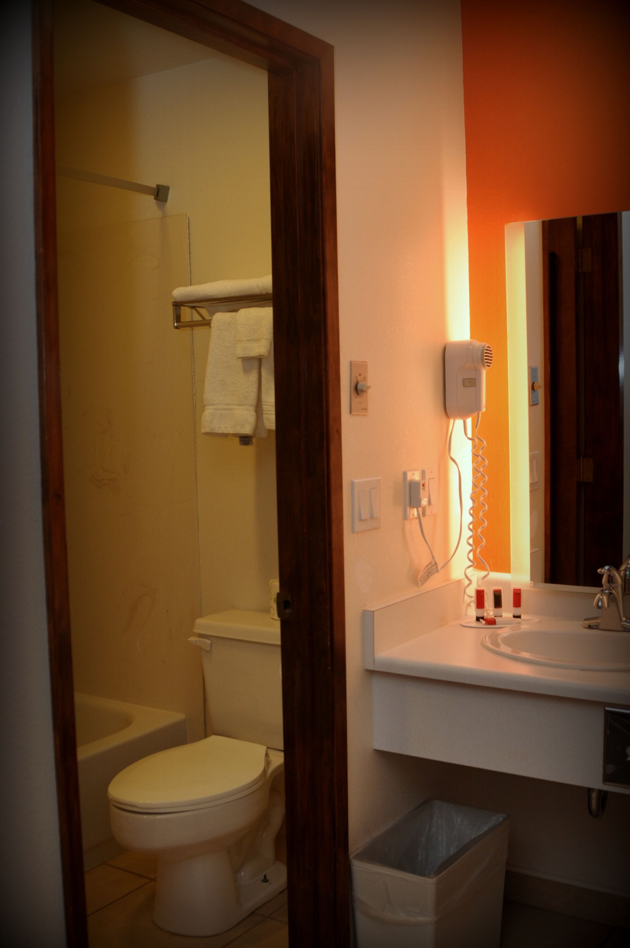 Ein Badezimmer mit Toilette, Dusche, Waschbecken und einem Fön an der Wand.