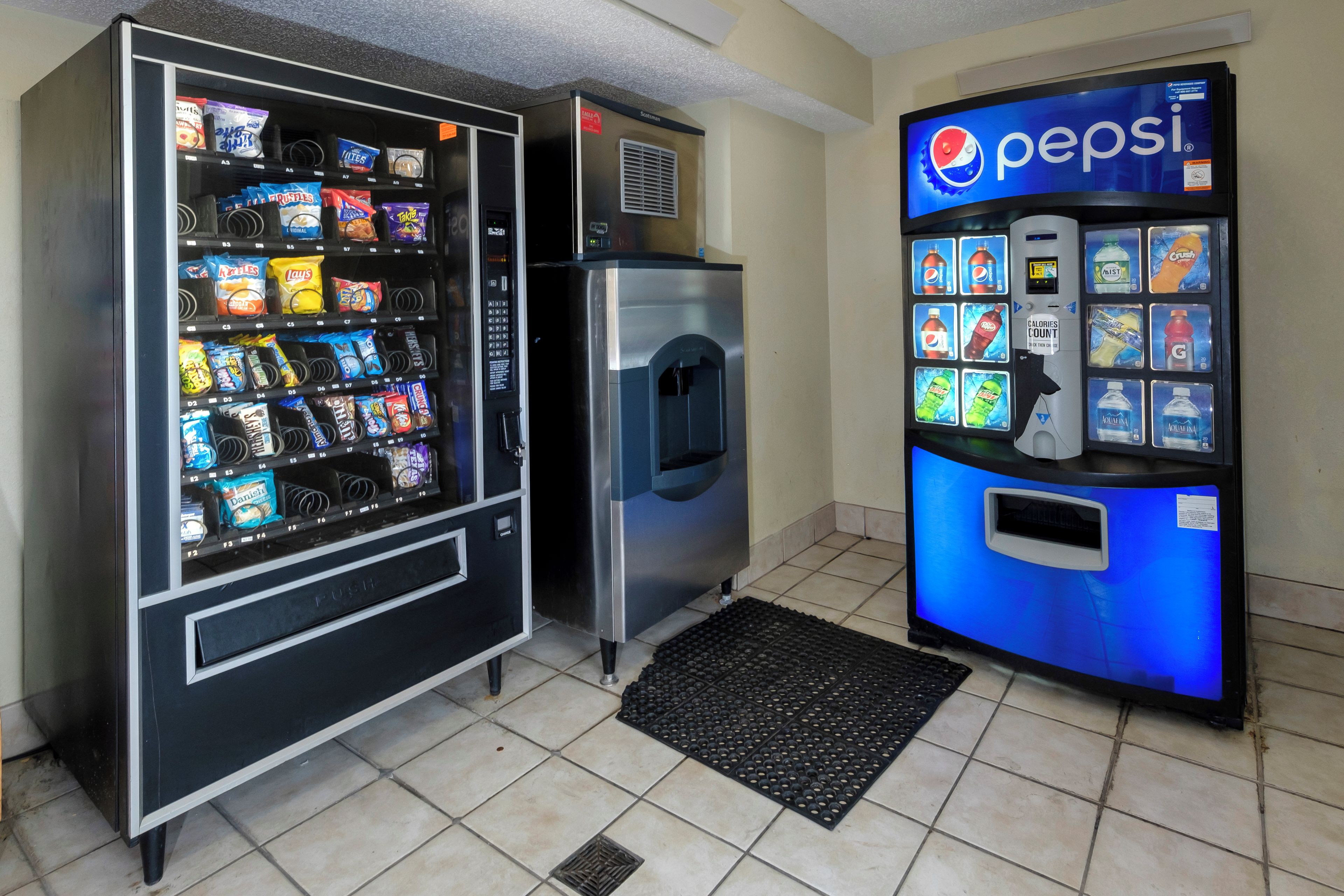 Zona de màquines expenedores amb opcions de menjar i una màquina de Pepsi.