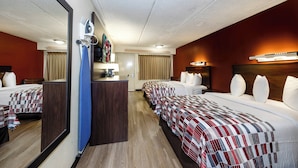 A hotel room with two beds, a desk, a mirror, and a television. - Red Roof Inn Tampa - Brandon (Tampa)