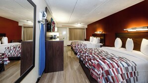 A hotel room with two beds, a desk, a mirror, and a television. - Red Roof Inn Tampa - Brandon (Tampa)