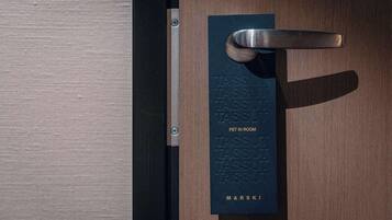 A door with a metal handle and a plaque that reads "TASSU PET IN ROOM" and "MARSKI".