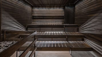 A sauna with wooden benches and a stone floor.
