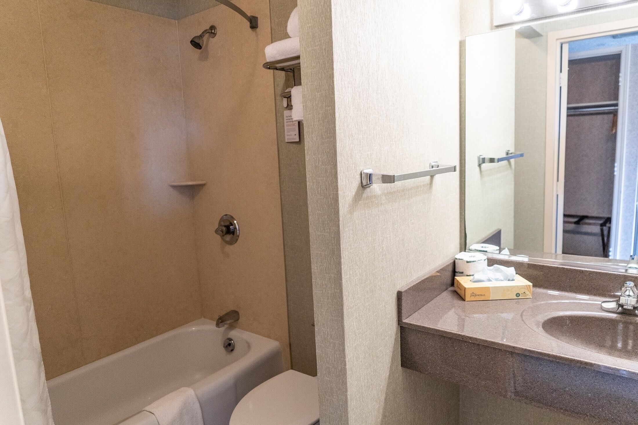 A bathroom with a bathtub, toilet, and a sink with a mirror.