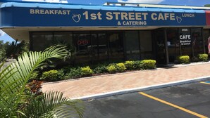 Un café situé sur la 1re rue, avec une enseigne indiquant qu’il propose des petits-déjeuners et des services de traiteur.