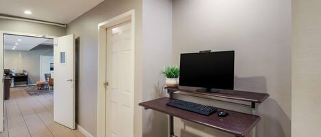 A modern home office with a desk, computer, and keyboard.