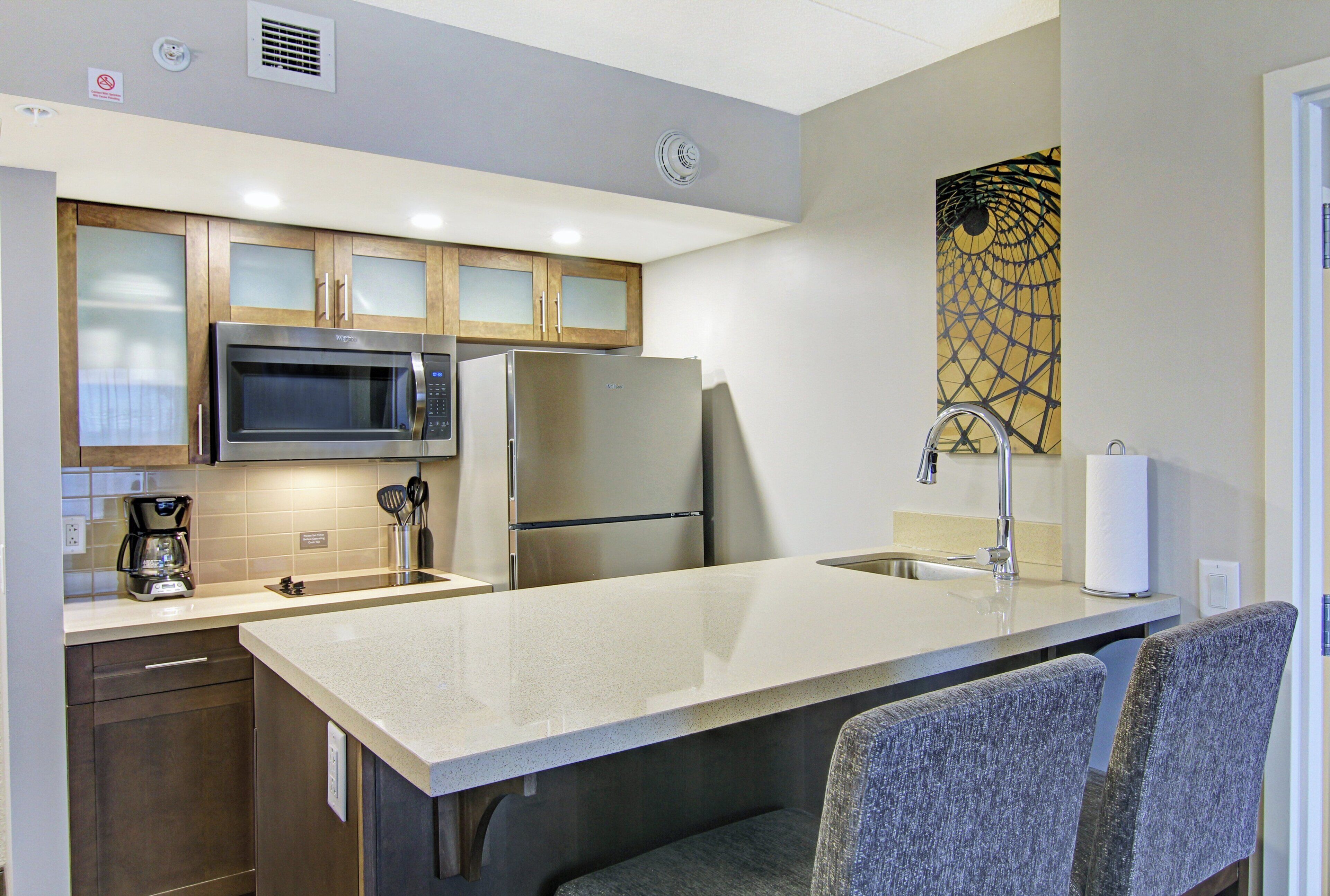 A compact kitchen with a microwave, refrigerator, and a coffee maker.