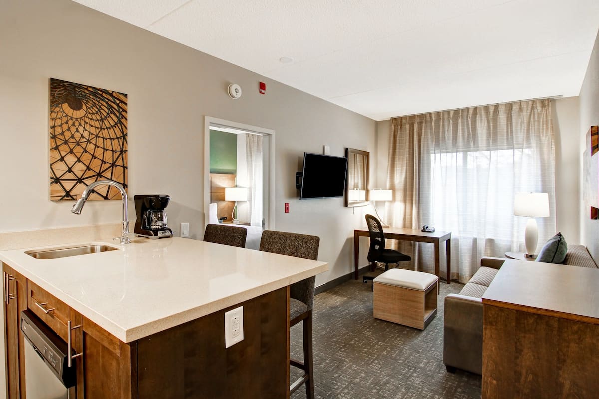 Une chambre d’hôtel équipée d’une kitchenette, d’un coin repas, d’un canapé et d’une télévision.