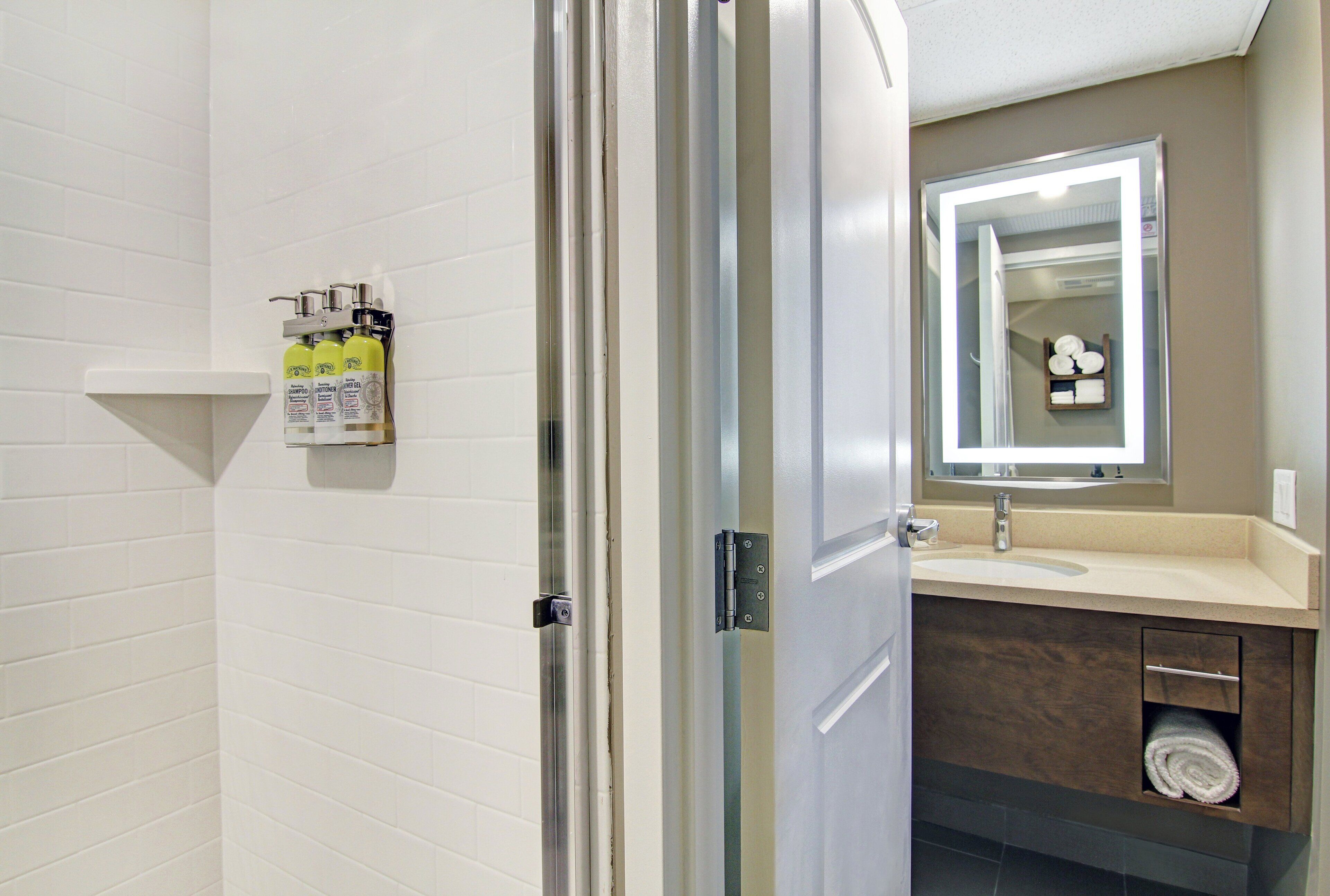 A bathroom with a shower, a sink, and a mirror.