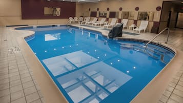 Relax by the pool surrounded by lounge chairs and mirrors.