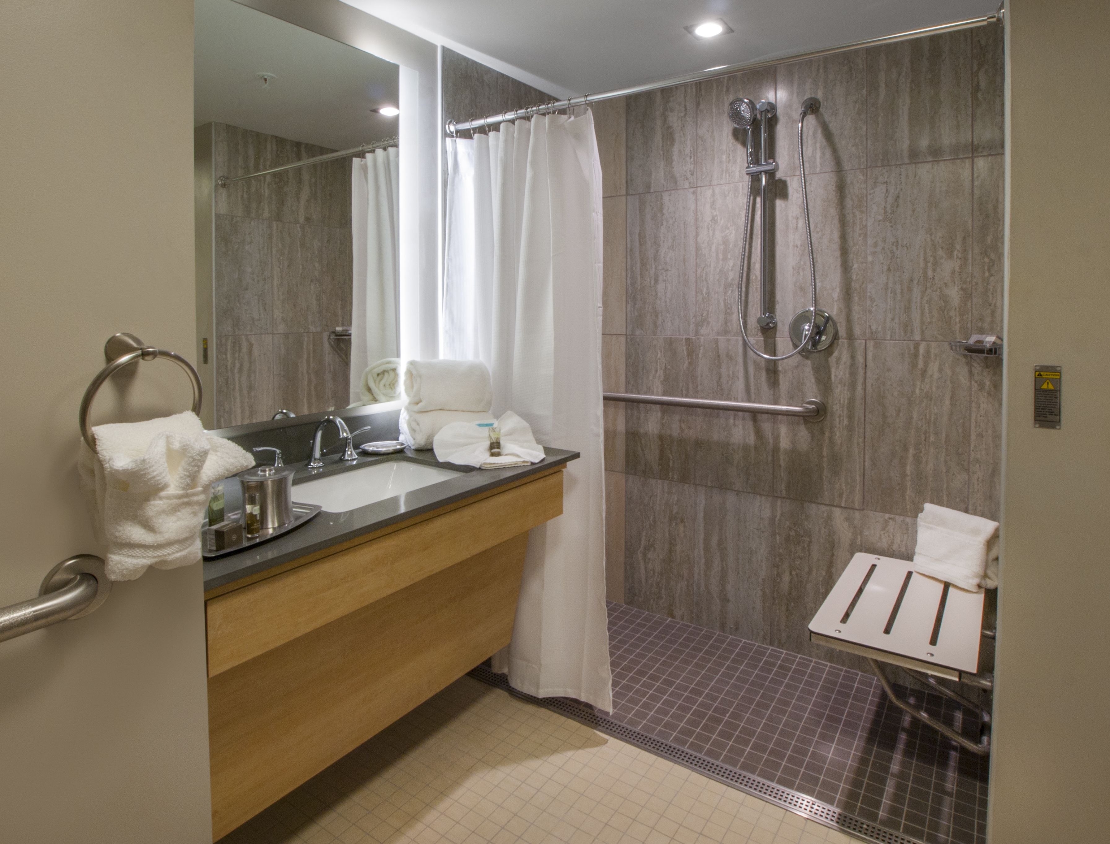 A modern bathroom with a sink, mirror, and shower.