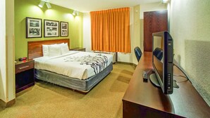 Une chambre d’hôtel équipée d’un lit, d’un bureau, d’une télévision et d’une table de chevet.
