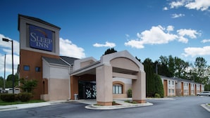 Un hôtel Sleep Inn doté d’une entrée moderne, d’une grande enseigne et d’un parking.
