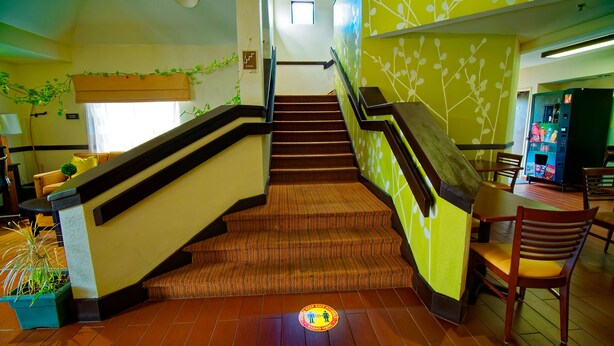 Un hall d’hôtel avec un escalier, un distributeur automatique et un espace détente.