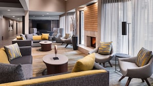 A modern living room with sofas, armchairs, and a fireplace.