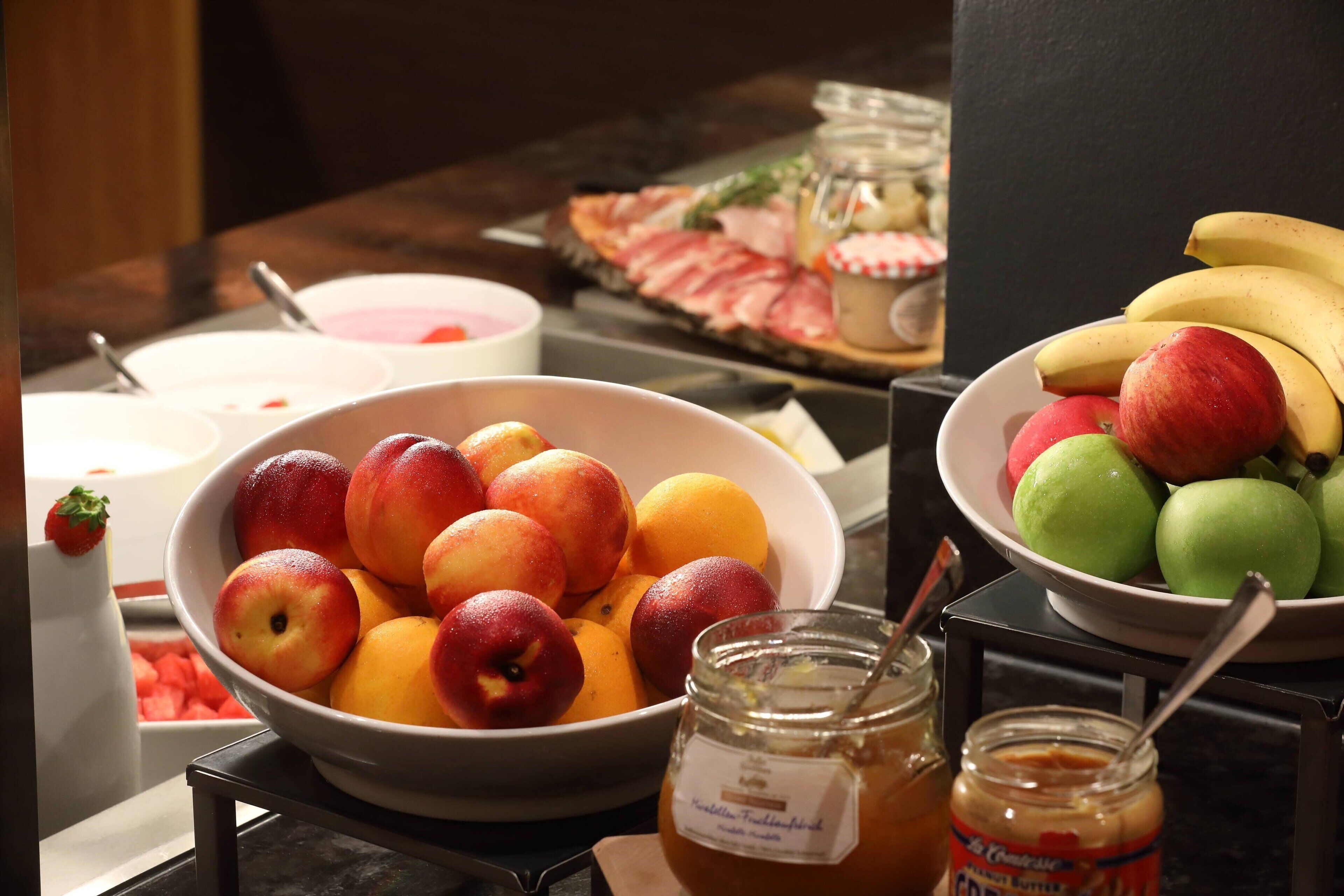 A buffet table with various fruits and condiments.