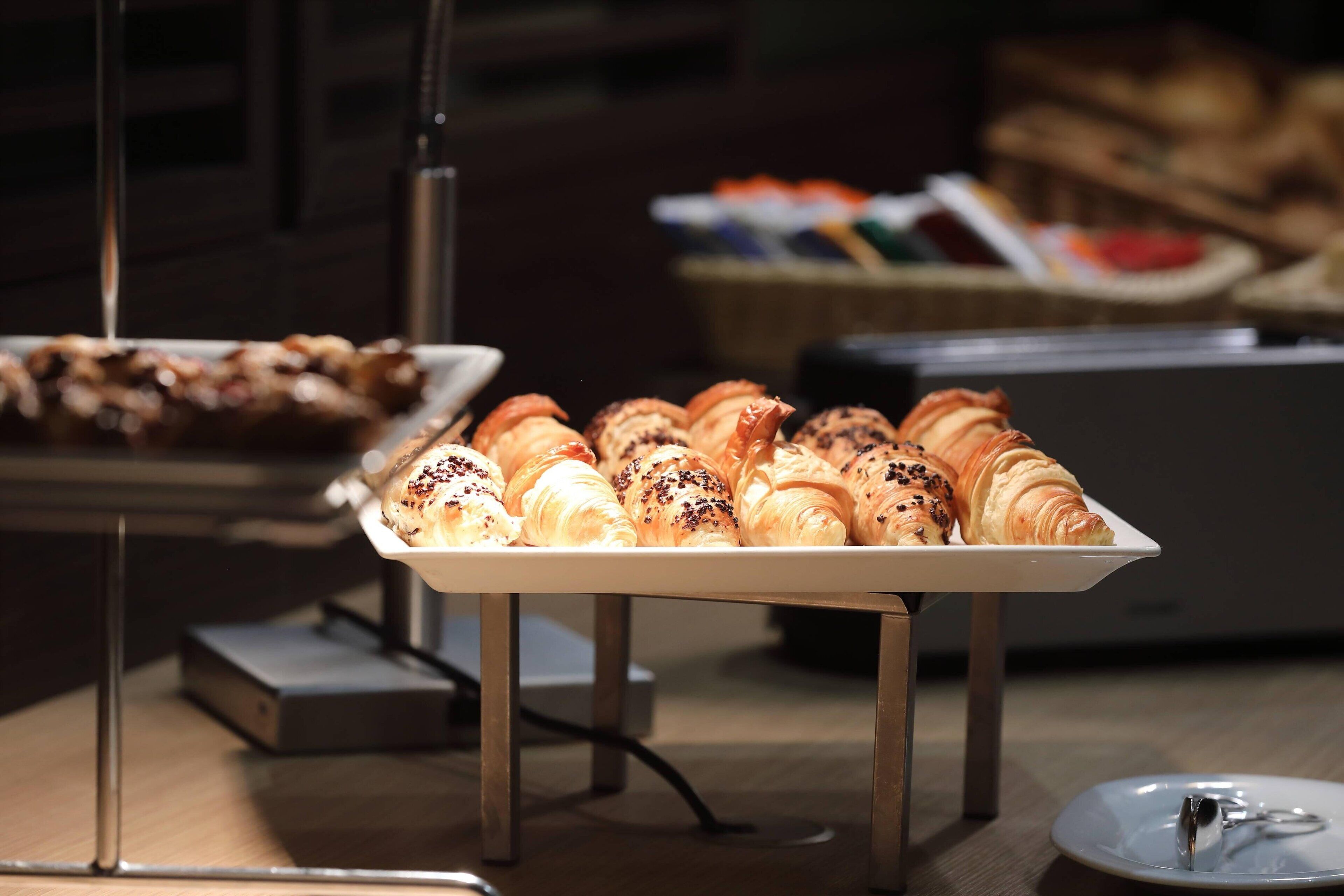 A buffet table with various pastries and baked goods.