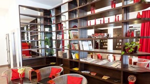 Eine moderne Bibliothek mit Bücherregalen, Leseangeboten und gemütlichen Sitzbereichen.