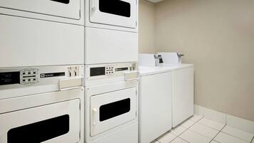 A laundry area with stacked dryers and a washing machine.