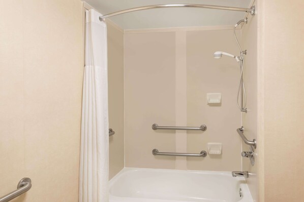 A walk-in shower with a bathtub, grab bars, and a showerhead.