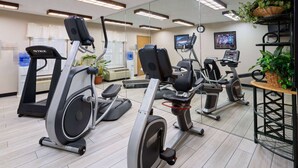 A gym with multiple treadmills, stationary bikes, and a mirrored wall. - Baymont by Wyndham Griffin (Griffin)