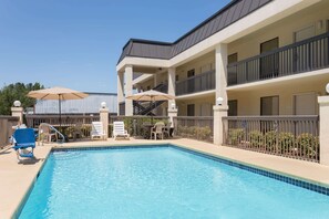 Relax by the pool surrounded by lush greenery and lounge under the shade of umbrellas.